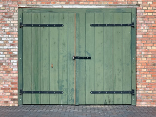 Sticker - Green large door and a rectangular low window on a brick wall building