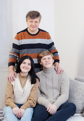 Wall Mural - father and two teenage children on  sofa at home