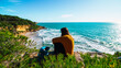 © aleiximg - Freedom Young Girl Sitting on the Edge of Cliff hearing Wind near Blue Sea Alone. Love and Success Concept