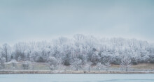 View Of Missouri River And Its Bluffs On Cold Winter Day; Trees On River Bank Covered With Snow And Frost
