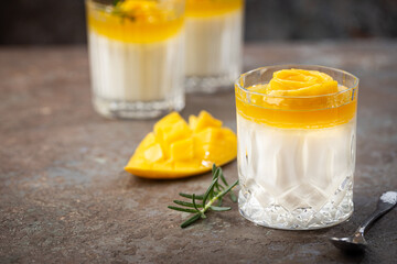 Wall Mural - Italian dessert panna cotta with mango in glass on gray background