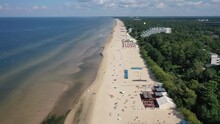 Jurmala, Majori, Latvia, Baltics. Beautiful Panoramic Aerial 4K Video From Flying Drone To Majori Sandy Beach Full Of People Sunbathing And Swimming In The Baltic Sea On A Hot And Sunny Summer Day. 