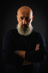 Wall Mural - close up photo, portrait of a serious, thoughtful, bearded man on a dark background confident and dramatic looking straight. Concept of male portrait.  Low key 