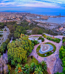 Poster - Aerial shot of a cityscape with a swimming pool near a sea during sunset