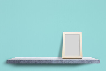 Empty photo frame wood on concrete shelves with cement pastel background.