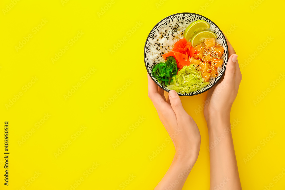 Woman with rice poke bowl on color background