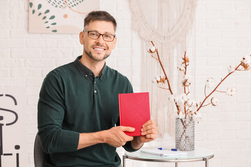 Poster - Handsome man with book at home