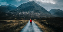 Woman Walking On A Road In Glen Etive, Scotland