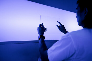 Researcher using a transparent digital tablet screen futuristic technology