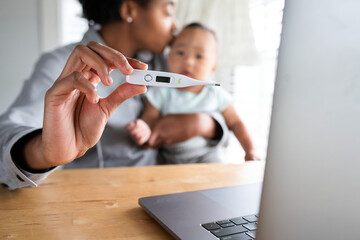 Wall Mural - African American mom showing baby’s fever to doctor through telemedicine call