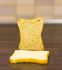 Poster - Closeup of a white flour bread pieces placed on a wooden table on a blurry background