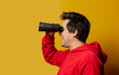 © Simonforstock - Smiling white guy in rd hoodie with binocular