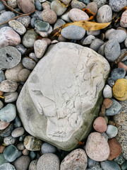 Sticker - Closeup vertical shot of a pile of colorful pebble stones on a Molen beach in Norway