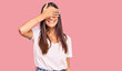 © Krakenimages.com - Young hispanic woman wearing casual white tshirt smiling and laughing with hand on face covering eyes for surprise. blind concept.