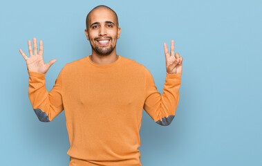 Canvas Print - Hispanic adult man wearing casual winter sweater showing and pointing up with fingers number seven while smiling confident and happy.