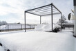 Wintereinbruch: Schnee bedeckt das Mobiliar einer luxuriösen Sonnenterrasse, über der sich ein leerer Pavillon erhebt