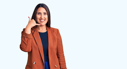 Poster - Young beautiful brunette woman wearing elegant clothes smiling doing phone gesture with hand and fingers like talking on the telephone. communicating concepts.