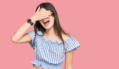 Sticker - Young beautiful caucasian girl wearing casual clothes smiling and laughing with hand on face covering eyes for surprise. blind concept.