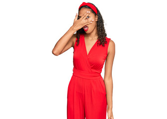 Poster - Young african american girl wearing elegant and sexy look peeking in shock covering face and eyes with hand, looking through fingers with embarrassed expression.