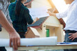 © Wasan - Construction project audit engineering team holds blueprints to examine the building's structure. The homeowners and contractors team are planning a home renovation.