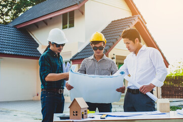 Three engineers working as a construction project inspector. The architects and engineers are discussing and planning projects for the house.