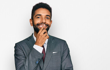 Canvas Print - Young african american man wearing business clothes looking confident at the camera with smile with crossed arms and hand raised on chin. thinking positive.