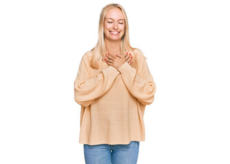 Sticker - Young blonde girl wearing casual clothes smiling with hands on chest with closed eyes and grateful gesture on face. health concept.