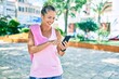 © Krakenimages.com - Middle age sportswoman smiling happy  using smartphone at the park