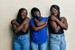 Three young african american friends wearing casual clothes hugging oneself happy and positive, smiling confident. self love and self care