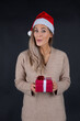 © MrsLePew - beautiful woman holding a Christmas and New Year gift. Christmas girl in santa hat with red box..