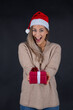 © MrsLePew - beautiful woman holding a Christmas and New Year gift. Christmas girl in santa hat with red box..