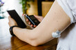 Modern diabetes treatment, woman checking glucose level and dosing insulin using insulin pump and remote sensor on her hand, focus on foreground