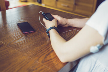 Sticker - Modern diabetes treatment, woman checking glucose level and dosing insulin using insulin pump and remote sensor on her hand