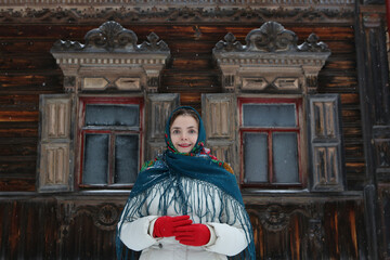 Wall Mural - Russian woman, girl. Pogorelovo terem. Wooden house with carved windows, ornamental frames in Pogorelovo village, Chukhloma, Kostroma region, Russia. Russian style in fashion, architecture. Landmark