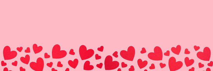 Aufkleber - Valentines Day bottom border of red paper hearts. Above view over a pink banner background. Copy space.