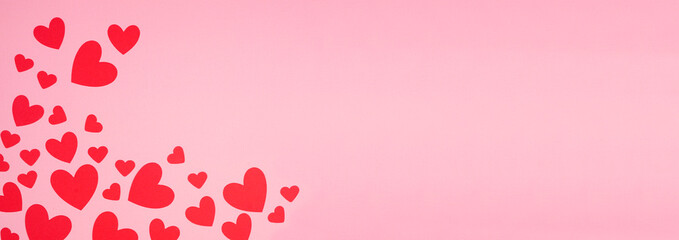 Poster - Valentines Day corner border of red paper hearts. Overhead view over a pink banner background. Copy space.