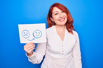 Wall Mural - Redhead coach woman asking for depression holding paper with emotion change message looking positive and happy standing and smiling with a confident smile showing teeth