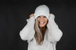 © MrsLePew - beautiful blonde woman pulling down woollen white hat and smiling