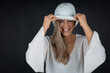 © MrsLePew - beautiful blonde woman pulling down woollen white hat and smiling