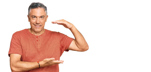 Sticker - Handsome middle age man wearing casual clothes gesturing with hands showing big and large size sign, measure symbol. smiling looking at the camera. measuring concept.