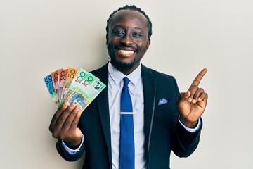 Poster - Handsome young black man wearing business suit and tie holding australian dollars smiling happy pointing with hand and finger to the side