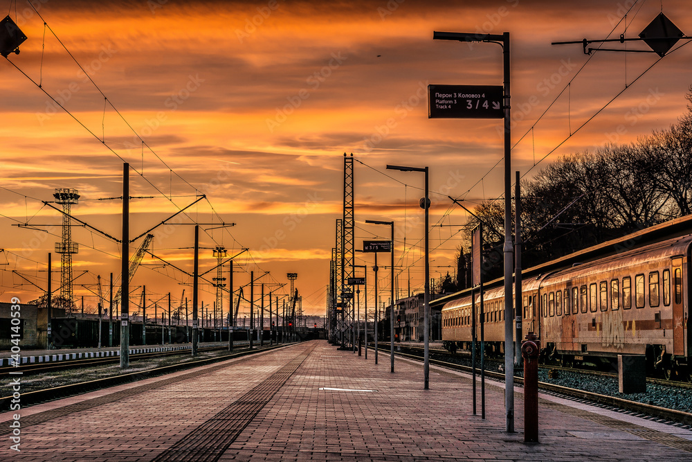Railroad Station Platform Against Sky During Sunset - obrazy, fototapety, plakaty 