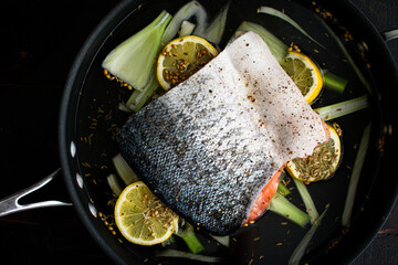 Wall Mural - Poached Salmon Fillet in a Skillet: A fish fillet on sliced lemon and fennel in a saute pan