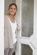 © MrsLePew - Cheerful young woman welcome friends at open front door