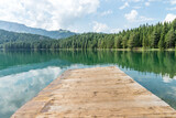 Fototapeta Perspektywa 3d - Empty angled wooden old pier on the Black lake sea shore