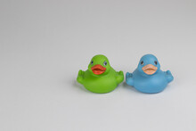 Blue And Green Rubber Ducks On A White Background