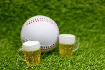 Wall Mural - Baseball with glasses of beer for party are on green grass