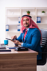 Wall Mural - Young male arab employee working in office