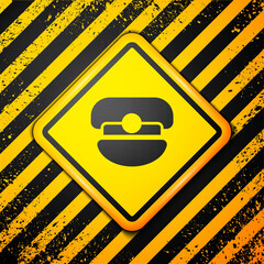 Sticker - Black Captain hat icon isolated on yellow background. Warning sign. Vector.