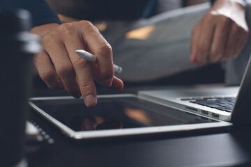 Poster - Close up of casual man hand using digital tablet during working on laptop computer at home